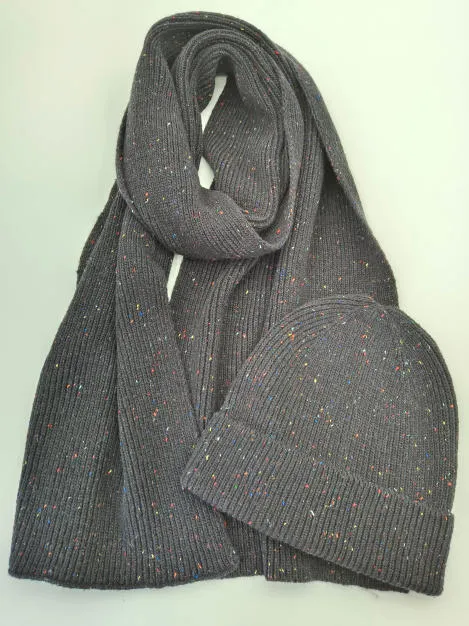 Grauer Rippstrickschal und passende Beanie-Mütze mit bunten Farbsprenkeln auf weißer Fläche