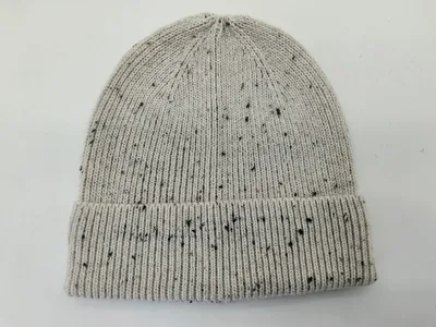 Hellgraue Strickmütze mit schwarzem Fleckenmuster und breitem umgeschlagenem Rippbündchen