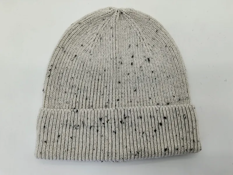 Hellgraue Strickmütze mit schwarzem Fleckenmuster und breitem umgeschlagenem Rippbündchen