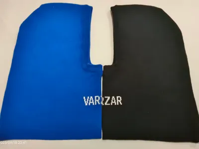 Blau-schwarze zweifarbige gestrickte Sturmhaube flach liegend mit Gesichtsausschnitt und Logoprint auf der schwarzen Seite