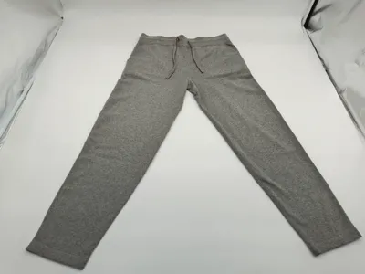 Aufgefaltete graue Melange-Jogginghose mit schmalem Schnitt, braunem Kordelzug am Bund und Seitentaschen in Produktfotografie