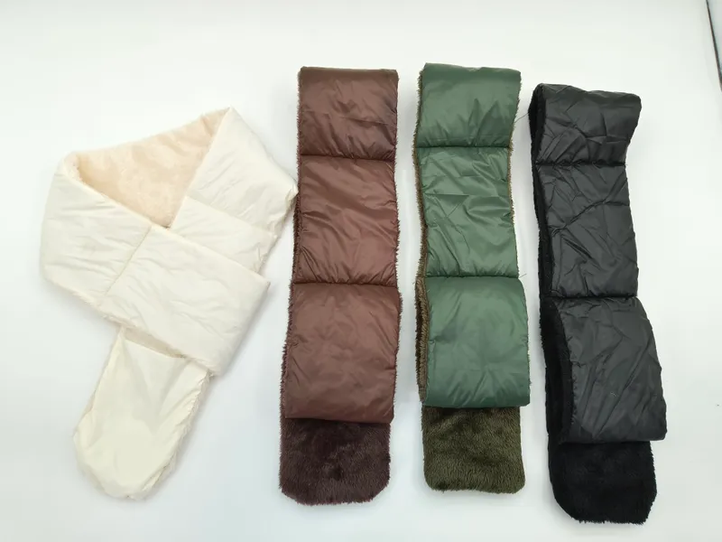 Vier gesteppte Puffer-Schals mit Kunstfell-Innenfutter nebeneinander in Creme, Braun, Olivgrün und Schwarz auf hellem Hintergrund