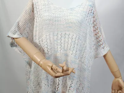 Weiß-blaues Multicolor-Häkel-Poncho-Top mit Kurzarm auf einer Schneiderpuppe, halbtransparentes Spitzenmuster in der Gesamtansicht