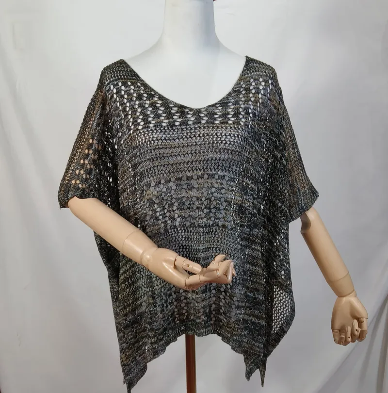 Dunkles Multicolor-Häkelponcho mit Kurzarm und asymmetrischem Saum auf einer Schneiderpuppe, Olive-Grau-Schwarz-Töne