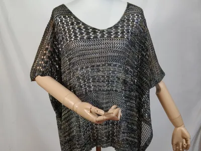 Dunkles Multicolor-Häkelponcho mit Kurzarm und asymmetrischem Saum auf einer Schneiderpuppe, Olive-Grau-Schwarz-Töne