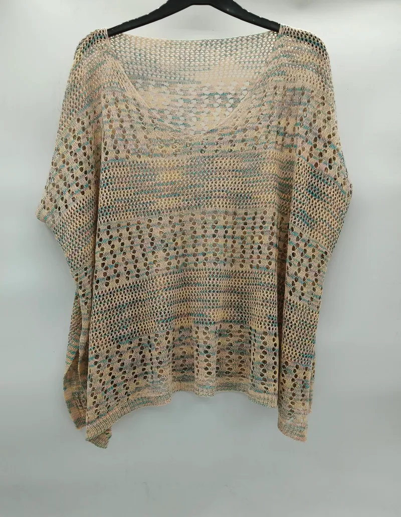 Beige-türkisfarbenes Häkelponcho mit Fledermausärmeln, Streifenmuster und großen Maschen auf einem Kleiderbügel in Studioaufnahme