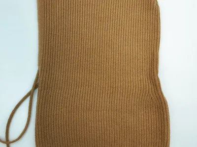 Kamelbraune Rippstrick-Balaclava-Kapuze mit verstellbaren Schnürbändern, flach auf weißem Hintergrund liegend