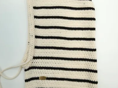 Creme-schwarz gestreifte Häkel-Balaclava flach liegend mit Ripprand, Schnürverschluss und kleinem goldenem Markenlabel