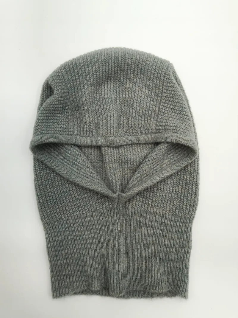 Graue Strick-Balaclava mit Rippenmuster als Gesichtsschutz, offene Gesichtsöffnung, Draufsicht auf weißem Untergrund