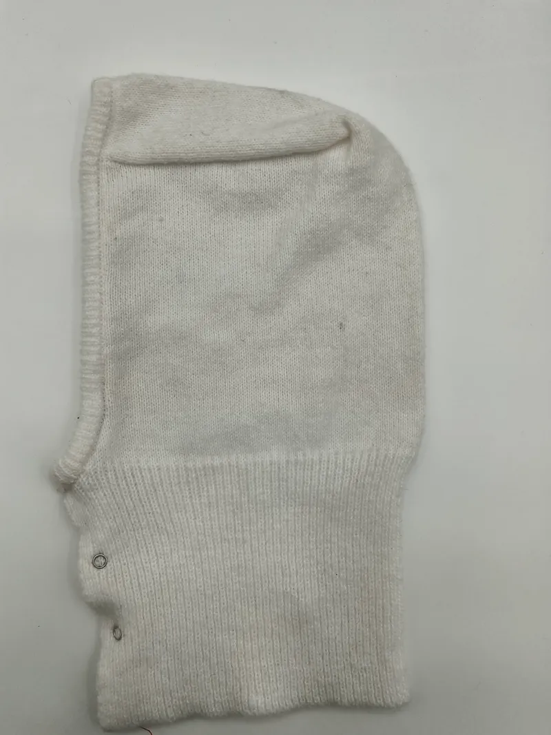 Weiße Strickhaube mit geripptem Abschluss und metallischen Druckknöpfen, vollflächige Gesichtsbedeckung auf hellem Hintergrund