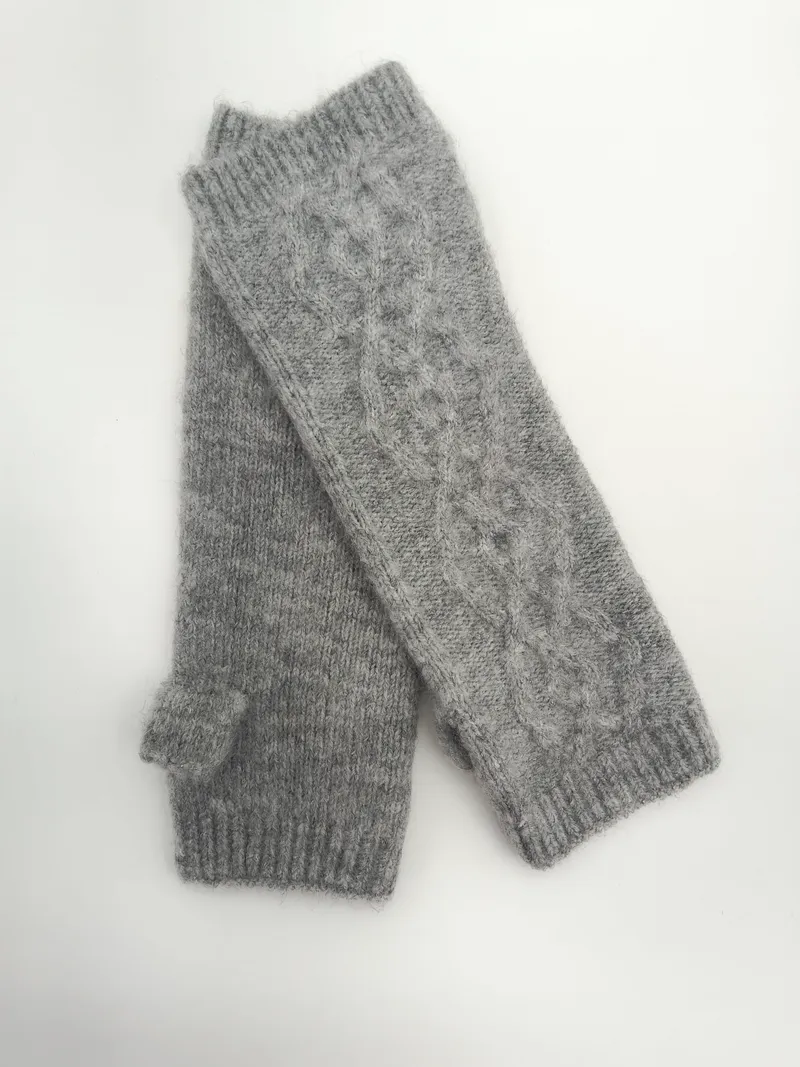 Paar graue fingerlose Handschuhe mit Zopfstrickmuster, Rippenbündchen und Daumenaussparung, flach auf weißem Untergrund