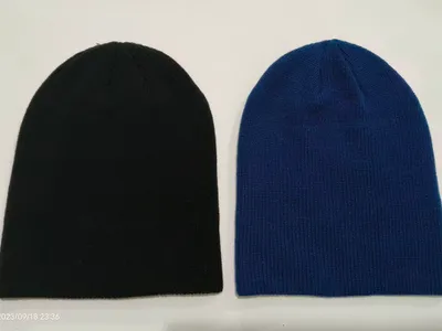 Zwei schlichte Slouchy-Beanies nebeneinander in Schwarz und Royalblau, gerippte Struktur ohne Bund, Studioaufnahme