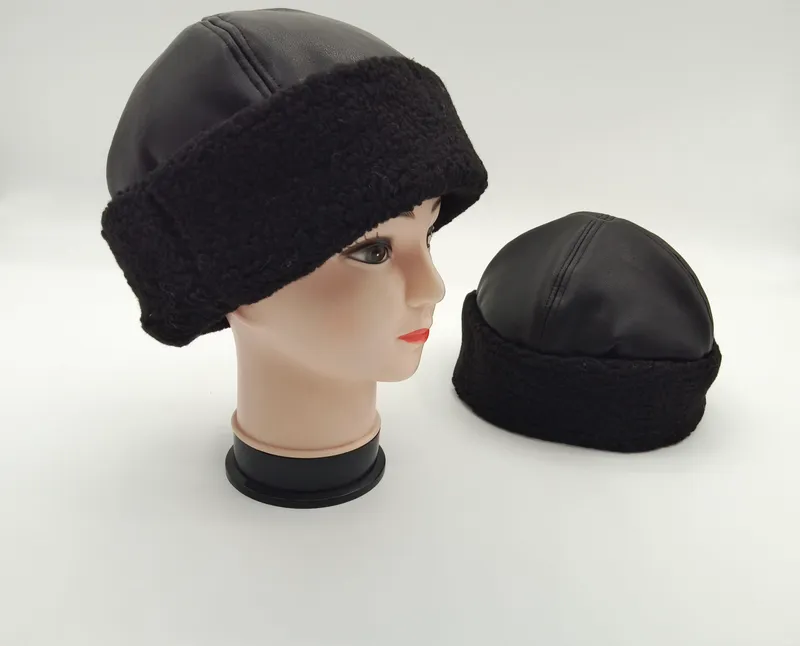 Schwarze Kunstleder-Beanie mit dicker Sherpa-Fleece-Krempe, auf Mannequin-Kopf und separat auf weißem Hintergrund präsentiert