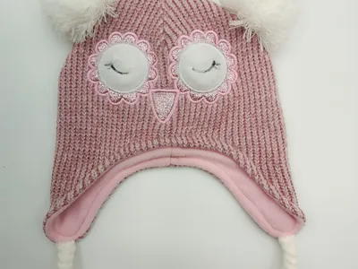 Rosa grob gestrickte Kinderwintermütze mit aufgesticktem Eulengesicht, weißen Bommeln, Ohrklappen und geflochtenen Quasten