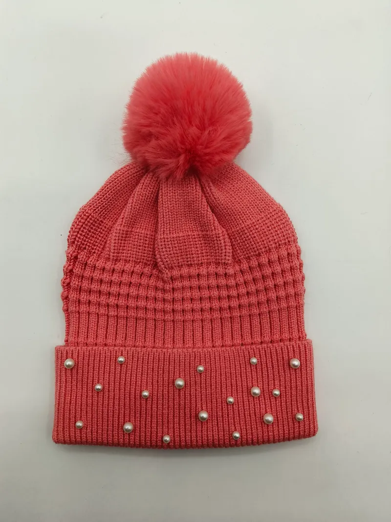 Lachs-rosafarbene Rippenstrick-Beanie mit Kunstfell-Bommel auf der Spitze und Perlen-Nieten-Verzierung am Bündchen