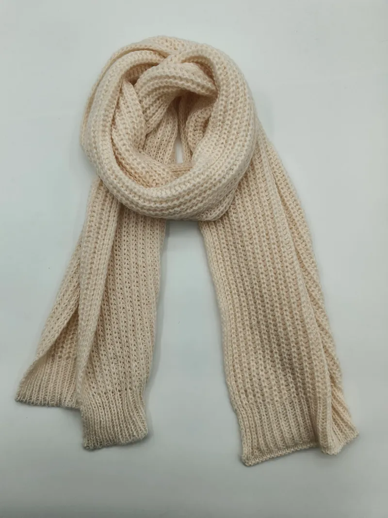 Cremefarbener Strickschal mit strukturierter Waffeloptik, locker aufgerollt und flach drapiert, Detailaufnahme der Textur