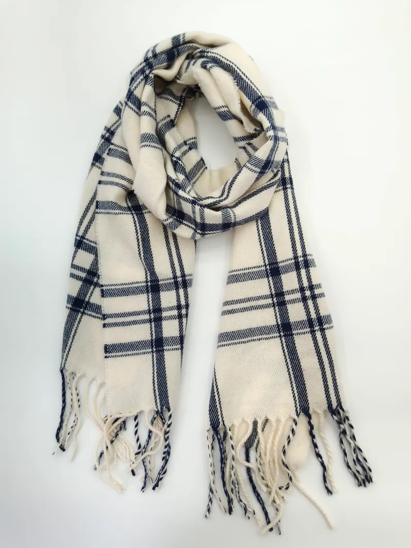 Klassisch karierter Schal in Creme und Dunkelblau mit gedrehten Fransenden, locker gelegt auf hellem Untergrund