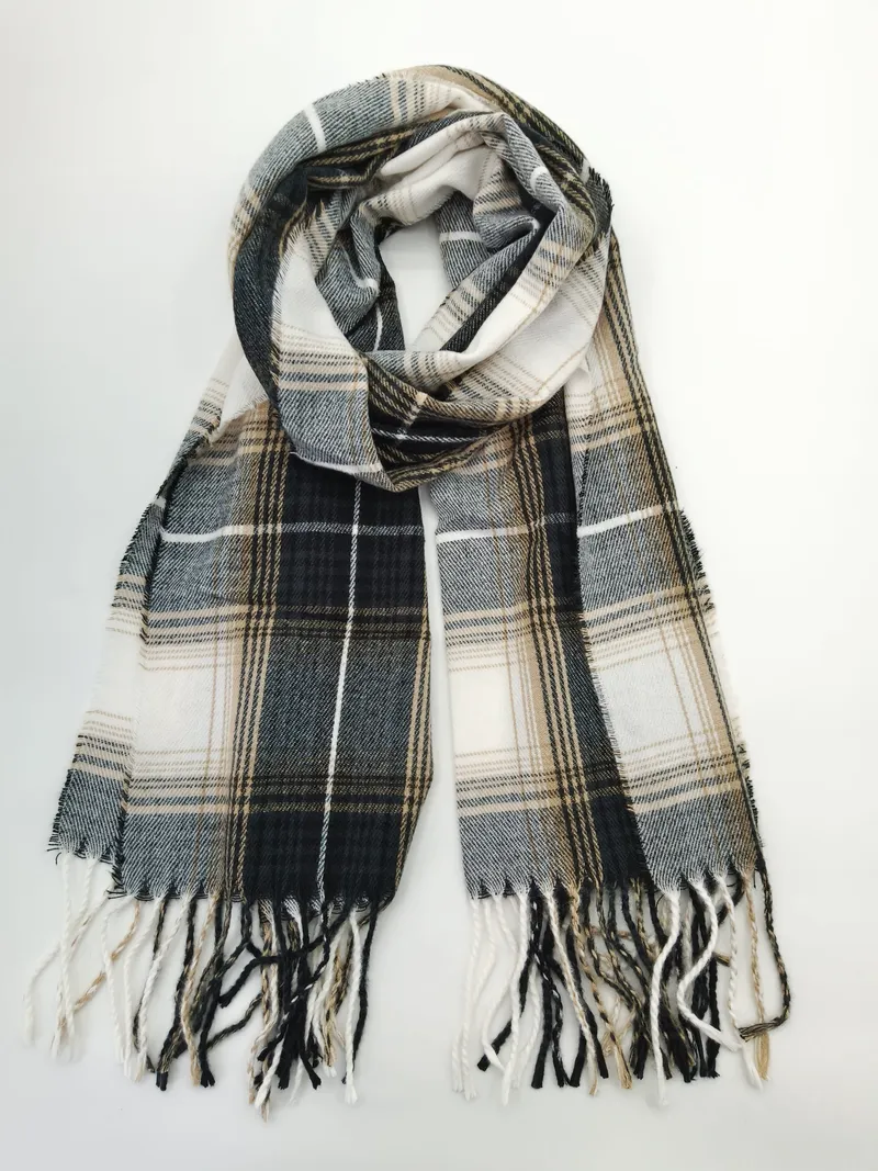 Gefalteter Tartan-Schal in den Farben Schwarz, Weiß und Sandbeige mit gedrehten Fransenenden auf weißem Untergrund