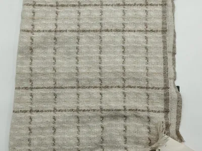 Gefaltete elfenbeinfarbene und beige gewebte Karoplaid-Decke mit Fransenrand und strukturiertem Gittermuster
