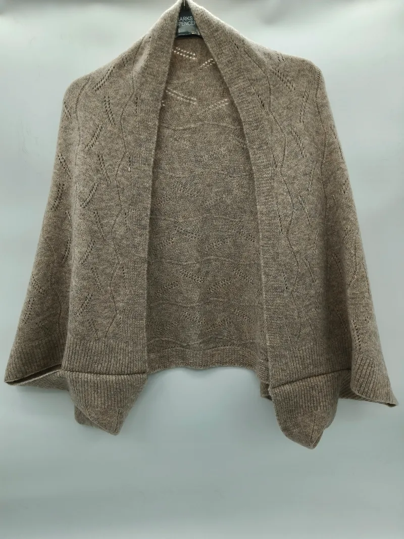 Taupefarbene beige Pointelle-Strick Schulterjacke mit offenem Vorderteil, Rautenspitzenmuster und gerippten Bündchen auf einem Kleiderbügel