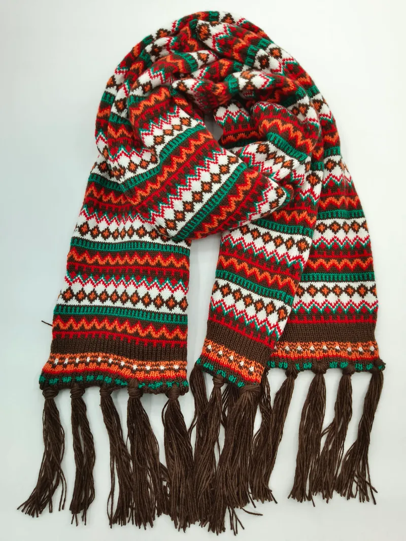 Bunter gestrickter Fair-Isle Schal mit geometrischen Mustern in Rot, Grün, Orange, Weiß und Braun sowie dunkelbraunen Fransenden