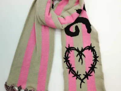 Gestrickter Schal in Beige und Rosa mit schwarzem Stacheldraht-Herz-Motiv und geknoteten Fransenden