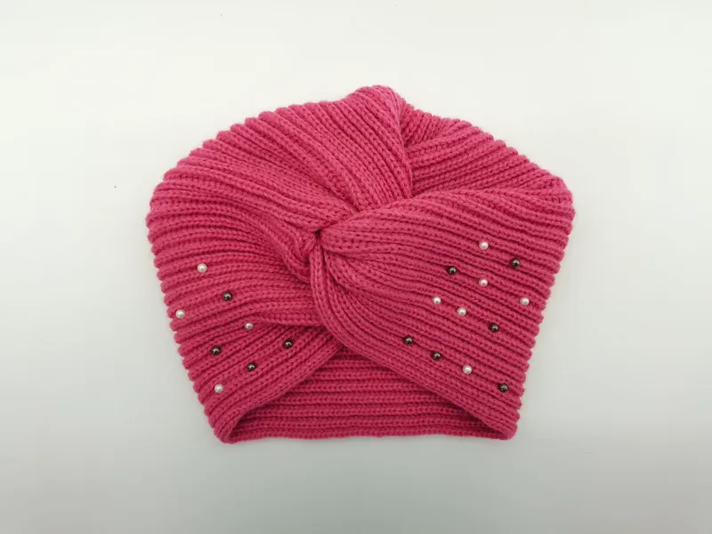 Rosafarbene Strickmütze im Turban-Stil mit Knotendetail an der Stirn und aufgenähten Zierperlen in Weiß und Anthrazit