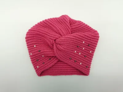 Rosafarbene Strickmütze im Turban-Stil mit Knotendetail an der Stirn und aufgenähten Zierperlen in Weiß und Anthrazit