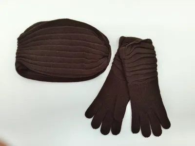 Dunkelbraune Rippenstrick-Wintermütze mit langen passenden Strickhandschuhen als Set auf weißem Hintergrund