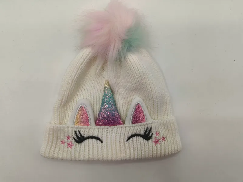 Weiße Rippenstrickmütze für Kinder mit Glitzerhorn, rosa Öhrchen, aufgestickten Wimpern, Sternchen und buntem Kunstfell-Pompon