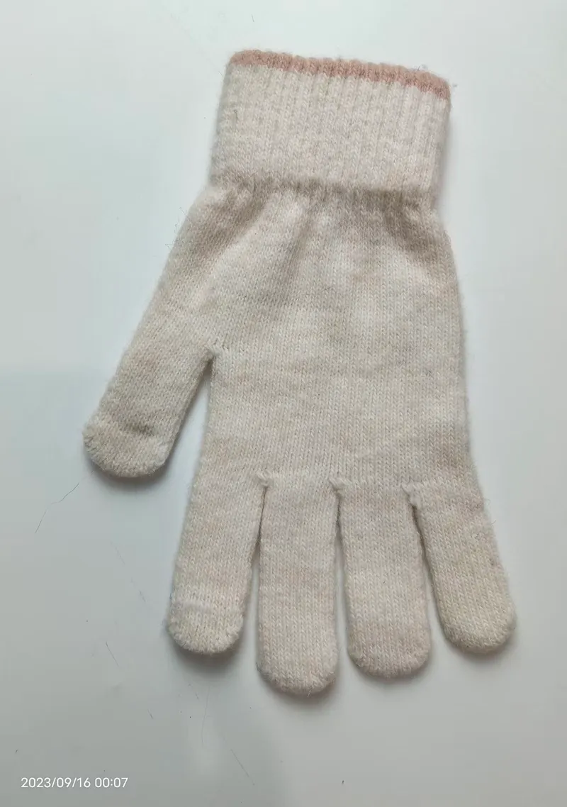 Ein einzelner cremefarbener Winterhandschuh mit geripptem Abschluss und zartem rosa Streifen-Detail, Draufsicht auf weißem Untergrund