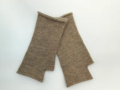 Paar fingerlose Strickhandschuhe in Taupe-Melange mit Daumenöffnung, flach auf weißem Untergrund liegend