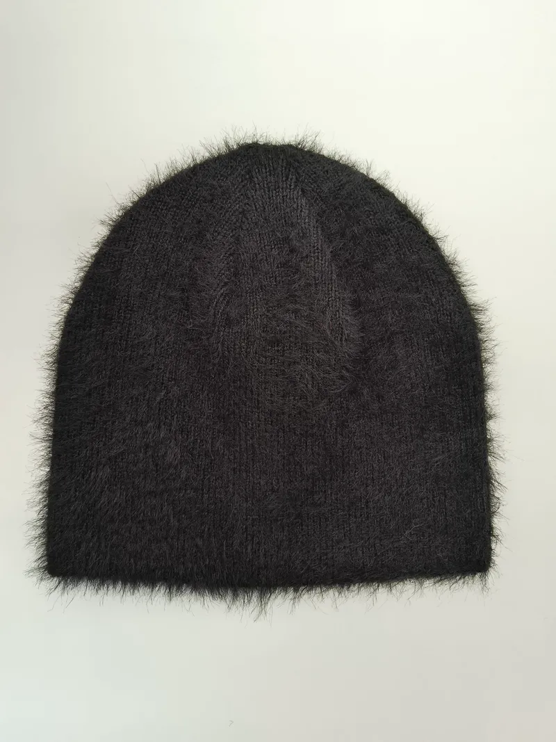 Schwarze Strickmütze mit flauschigen Mohair-artigen Fasern und gerippter Struktur, flach auf weißem Hintergrund liegend