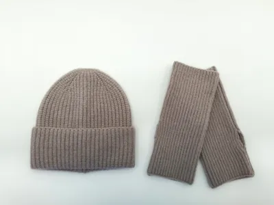 Taupefarbenes Winter-Set aus gerippter Strickmütze und passenden fingerlosen Handschuhen, flach auf weißem Hintergrund