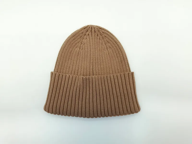 Hellbraune grob gestrickte Wintermütze mit umgeschlagenem Bund und sichtbarer Rippenstruktur, von vorne fotografiert