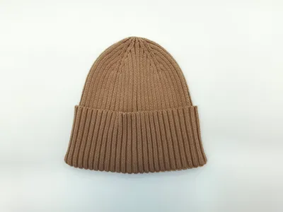 Hellbraune grob gestrickte Wintermütze mit umgeschlagenem Bund und sichtbarer Rippenstruktur, von vorne fotografiert