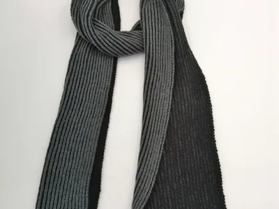 Rippenstrickschal in Anthrazit und Schwarz, aufgefaltet und locker drapiert, mit sichtbarem Strickmuster