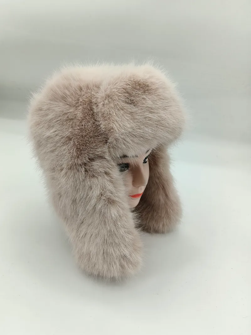 Flauschige Kunstpelzmütze in Beige im Ushanka-Stil mit langen Ohrklappen auf einem Modellkopf, seitliche Ansicht