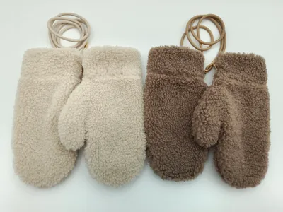 Zwei Paar flauschige Plüsch-Winterhandschuhe in Weißcreme und Graubraun, jeweils mit Leder-Haltekordel am Handgelenk, auf hellem Hintergrund
