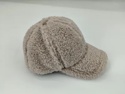Strukturiertes Baseballcap aus flauschigem Beige-Teddystoff mit Nähten der 6-Panel-Konstruktion und festem Schirm, auf neutralem Hintergrund