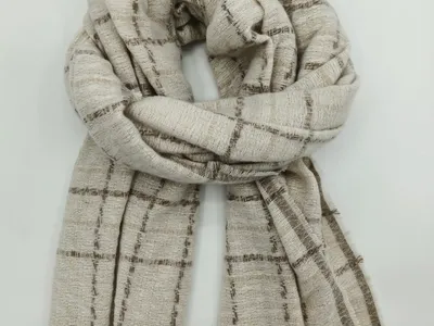 Leichter Schal in Creme und Braun mit klassischem Karomuster und fransig ausgearbeiteten Schmalseiten, locker drapiert auf weißem Hintergrund