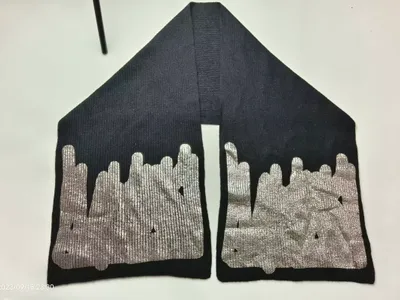 Schwarzer Strickschal mit glänzendem Silber-Metallic-Aufdruck in Tropfenoptik an beiden Schalenden, auf weißem Untergrund