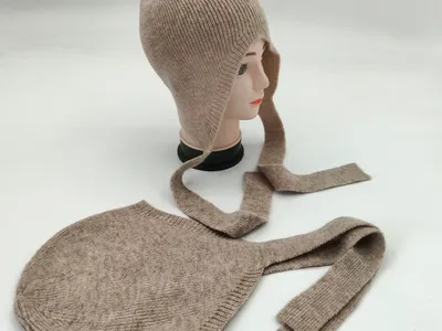 Beige gerippte Strickmütze im Bonnet-Stil mit langen Bindebändern, auf einem Hutständer und als Flachbild-Ansicht präsentiert