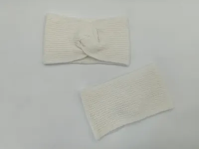 Creme geripptes Strick-Stirnband mit Twist-Knoten und passender Pulswärmer, flach auf weißer Oberfläche ausgelegt