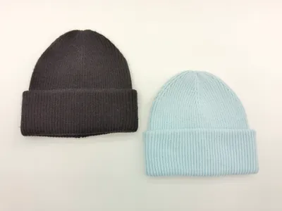 Zwei gerippte Umschlagrand-Beanies nebeneinander – eine in Anthrazitgrau und eine in Hellblau – auf weißem Hintergrund