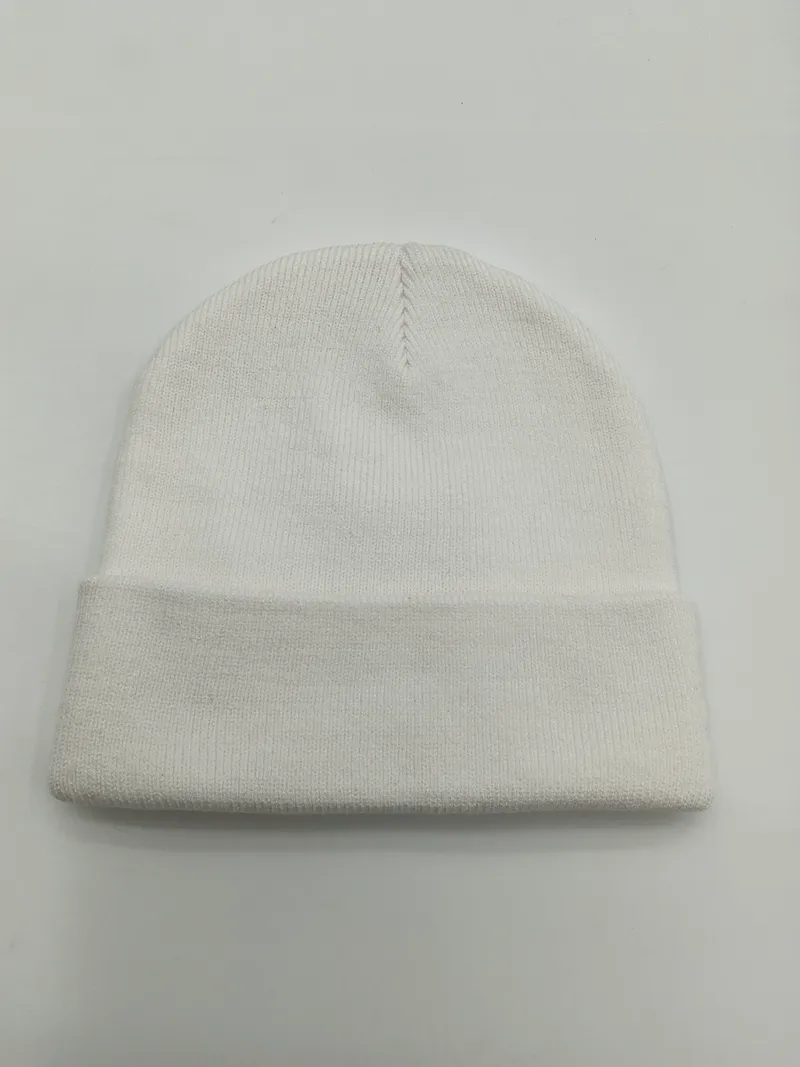 Weiße Strickmütze mit feinem Rippenmuster und gerolltem Bündchen, flach auf hellem Untergrund fotografiert, sichtbare Naht an der Spitze