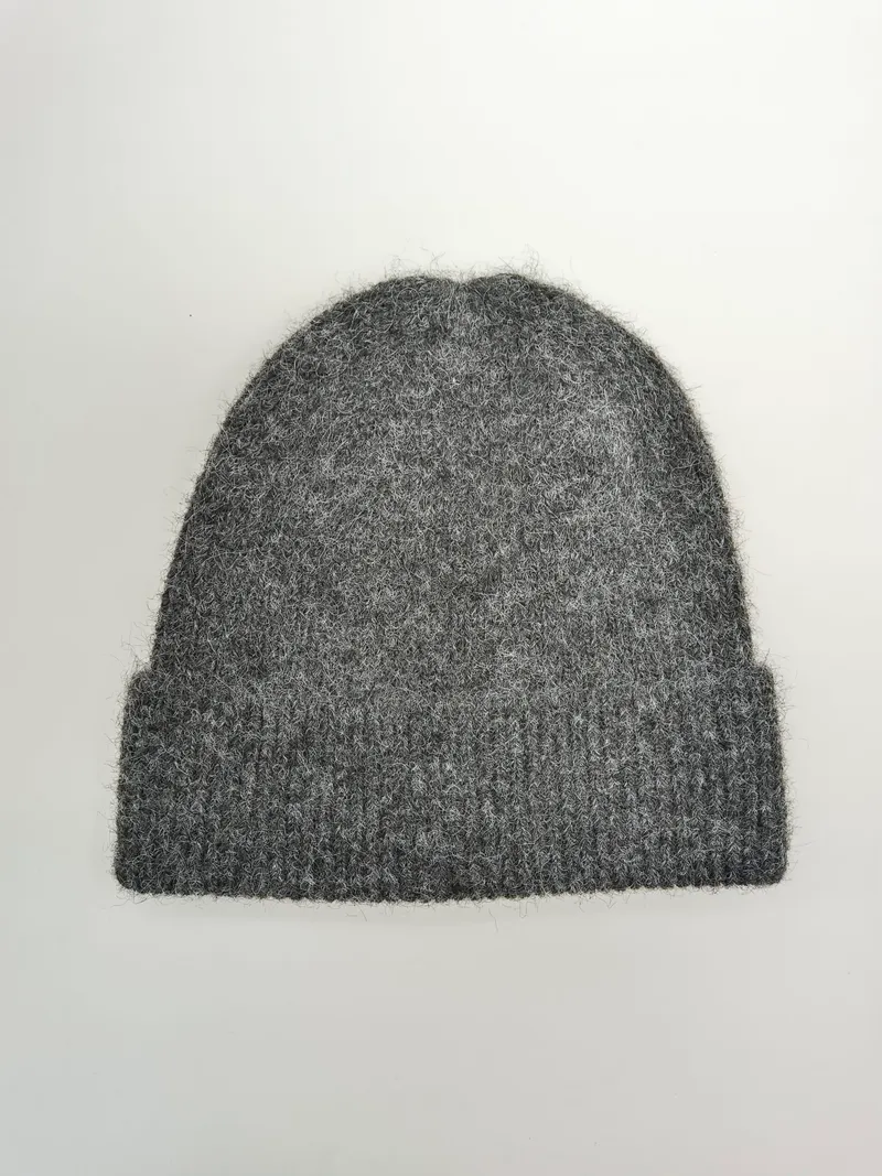 Weiche, flauschige Strickmütze in Grau mit breitem Rippenbündchen, flach fotografiert auf weißem Untergrund