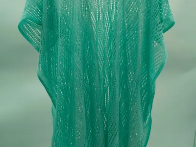 Mintfarbener Häkel-Kimono mit welligem Lochmuster, kurzen Ärmeln und langem Schnitt, auf einem Kleiderbügel präsentiert