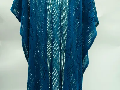 Petrolblauer langer Häkel-Kimono mit Wellenmuster in offenem Strickgewebe auf Kleiderbügel vor weißem Hintergrund