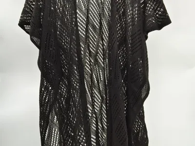 Schwarzer grobmaschiger Häkel-Kimono mit diagonalem Lochmuster auf Kleiderbügel vor weißem Hintergrund